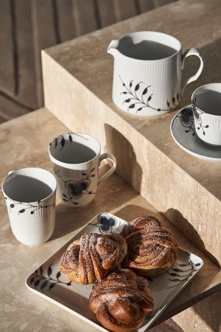 Black fluted mega mjölkkanna, tallrik med kanelbullar och kopp med fat från Royal Copenhagen i svart och vitt - perfekt till fikastunden.