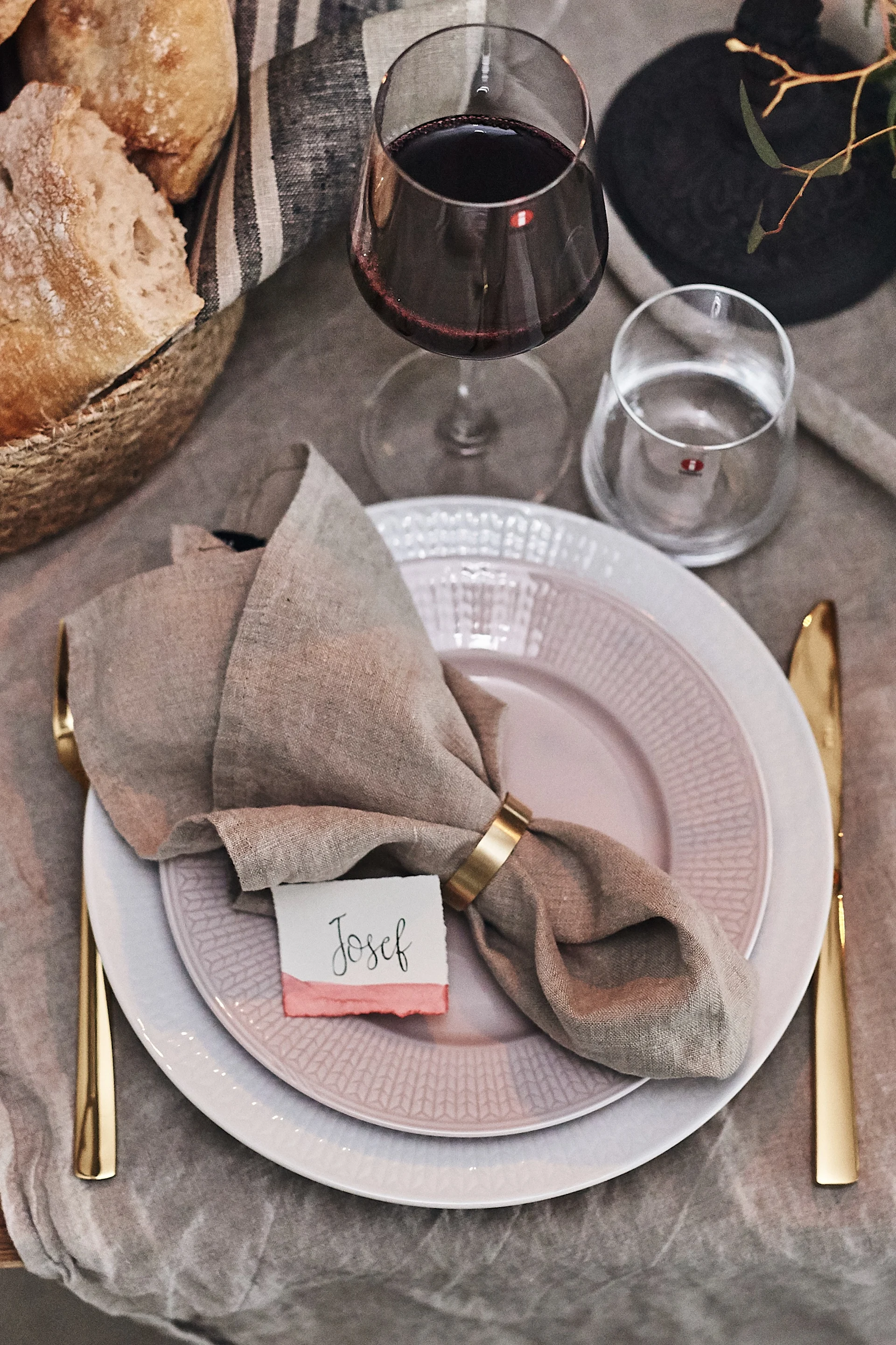 En vacker festdukning med linneduk på sniskan och en beige linneservett enkelt vikt med servettring.
