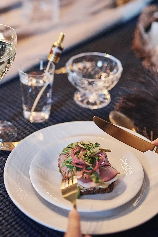 Klassisk och elegant festdukning med vita tallrikar från Swedish Grace-serien från Rörstrand och mässingsbestick.