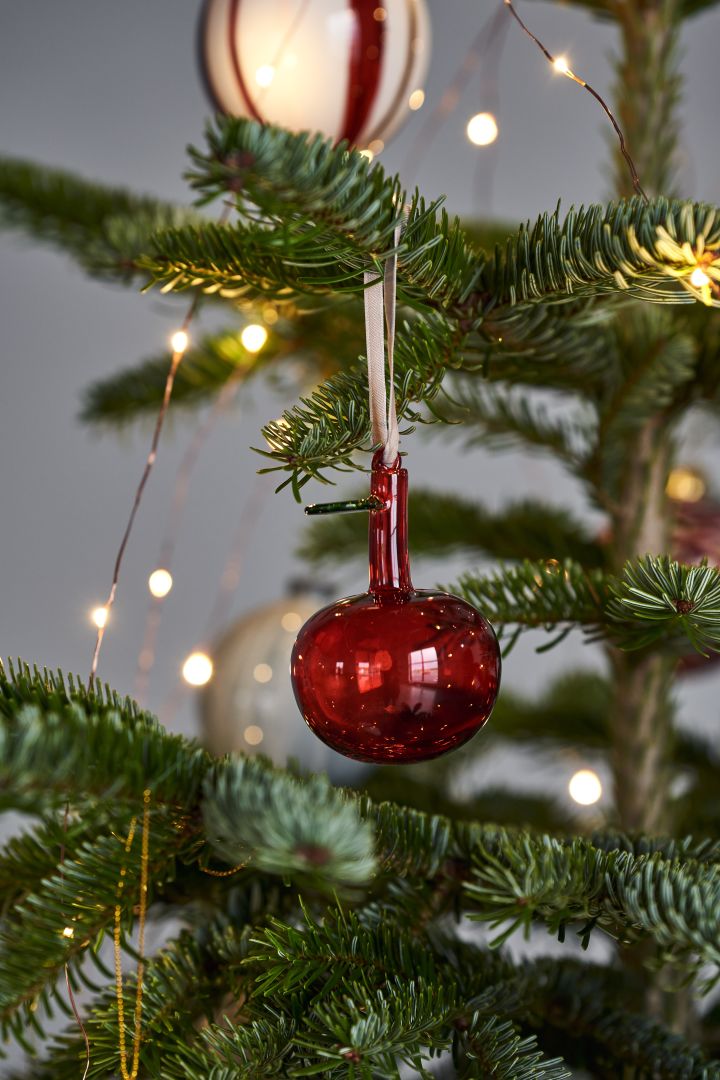 Dekorera julgranen med årets julgranspynt 2021 i 4 olika stilar enligt Nest Trends - Nurture, Share, Boost och Cultivate. Här ser du Iittala glasäpple i rött.