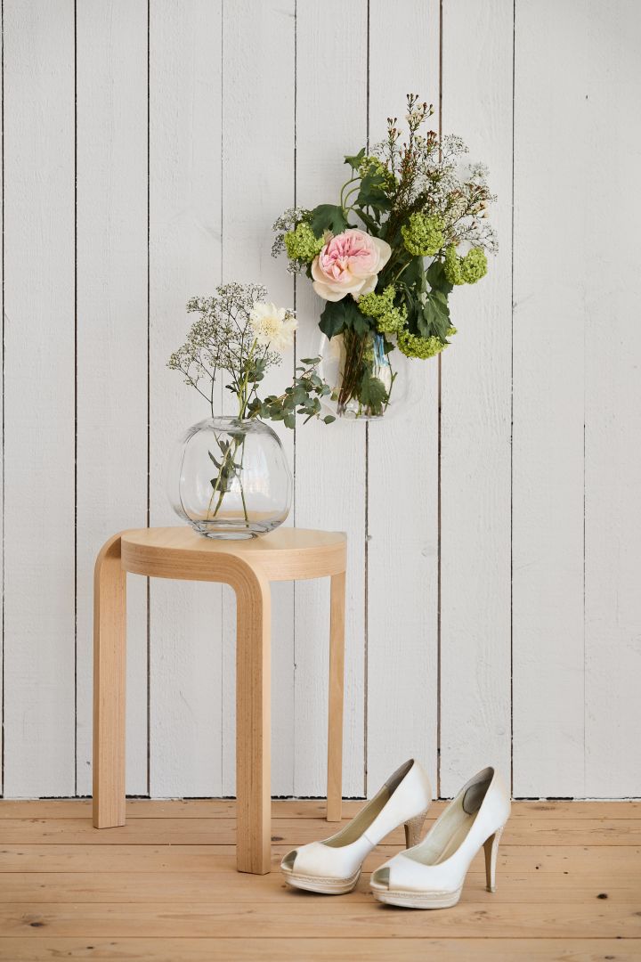 Tips till ditt bröllop - dekorera varje rum med färska snittblommor i vaser så är varje ögonblick redo för en bild. Här en rund glasvas på pall i ek med brudskor.