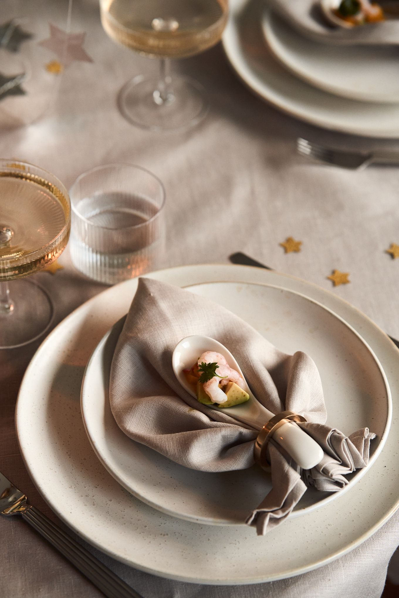Vasa servettring i brons från Himla tillsammans med Clean linneservett i greige från Scandi Living bildar tillsammans den vackra servettvikningen Musslan.