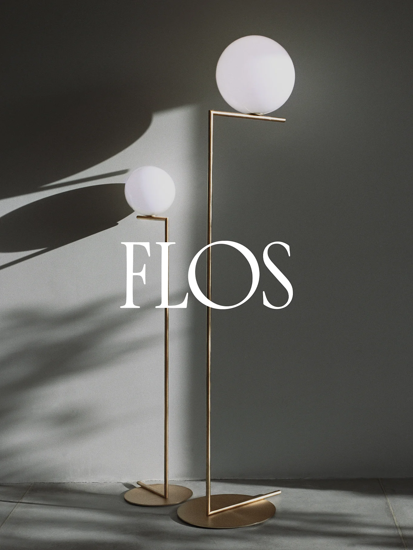 Två moderna golvlampor med sfäriska vita diffusorer och guldmetallramar, med Flos-logotypen.
