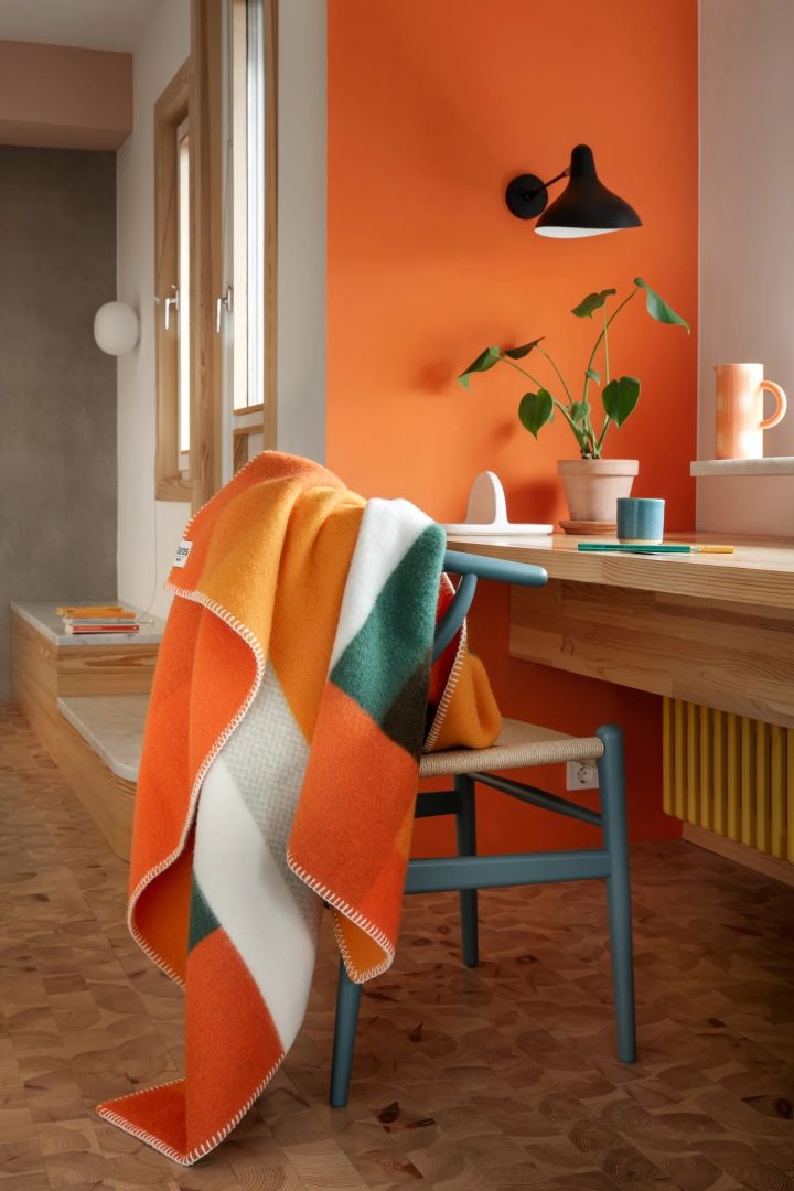 Orange gör comeback bland årets färgtrender 2024 och kan visas i din inredning med hjälp av en härligt retro-inspirerad pläd som denna Mikkel filt från Røros.