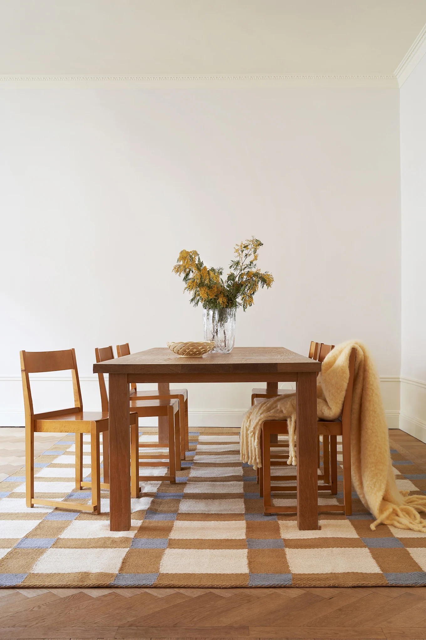 Smörgult är en av färgtrenderna 2026. Här syns en rutig matta från Layred i denna nyans, med ett matbord och stolar placerade ovanpå.