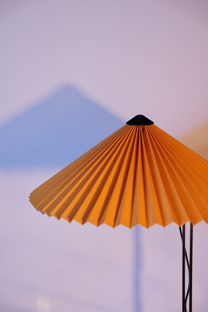 Orange gör comeback bland årets färgtrender 2023 och kan visas i din inredning med hjälp av en bordslampa med vackert plisserad skärm i orange från HAY.