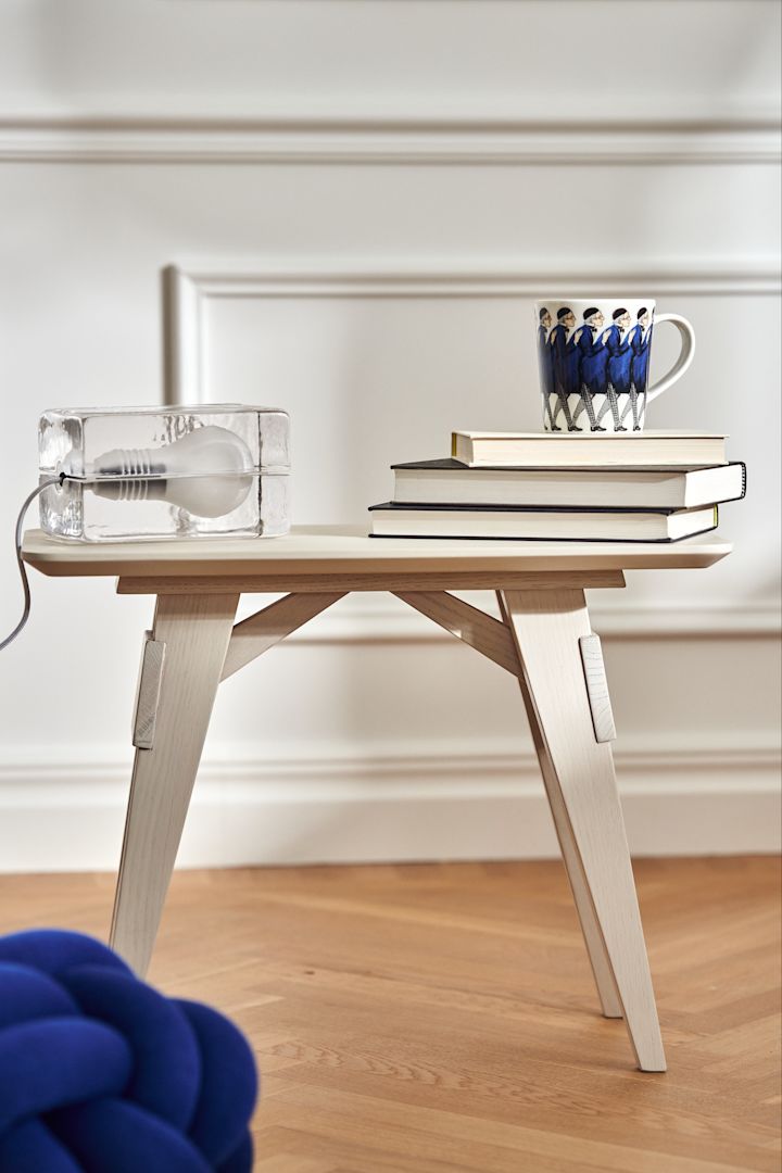 Bord i vit ek från Design House Stockholm, på det vilar lampan Block och Elsa Beskow-muggen Farbror Blå. 