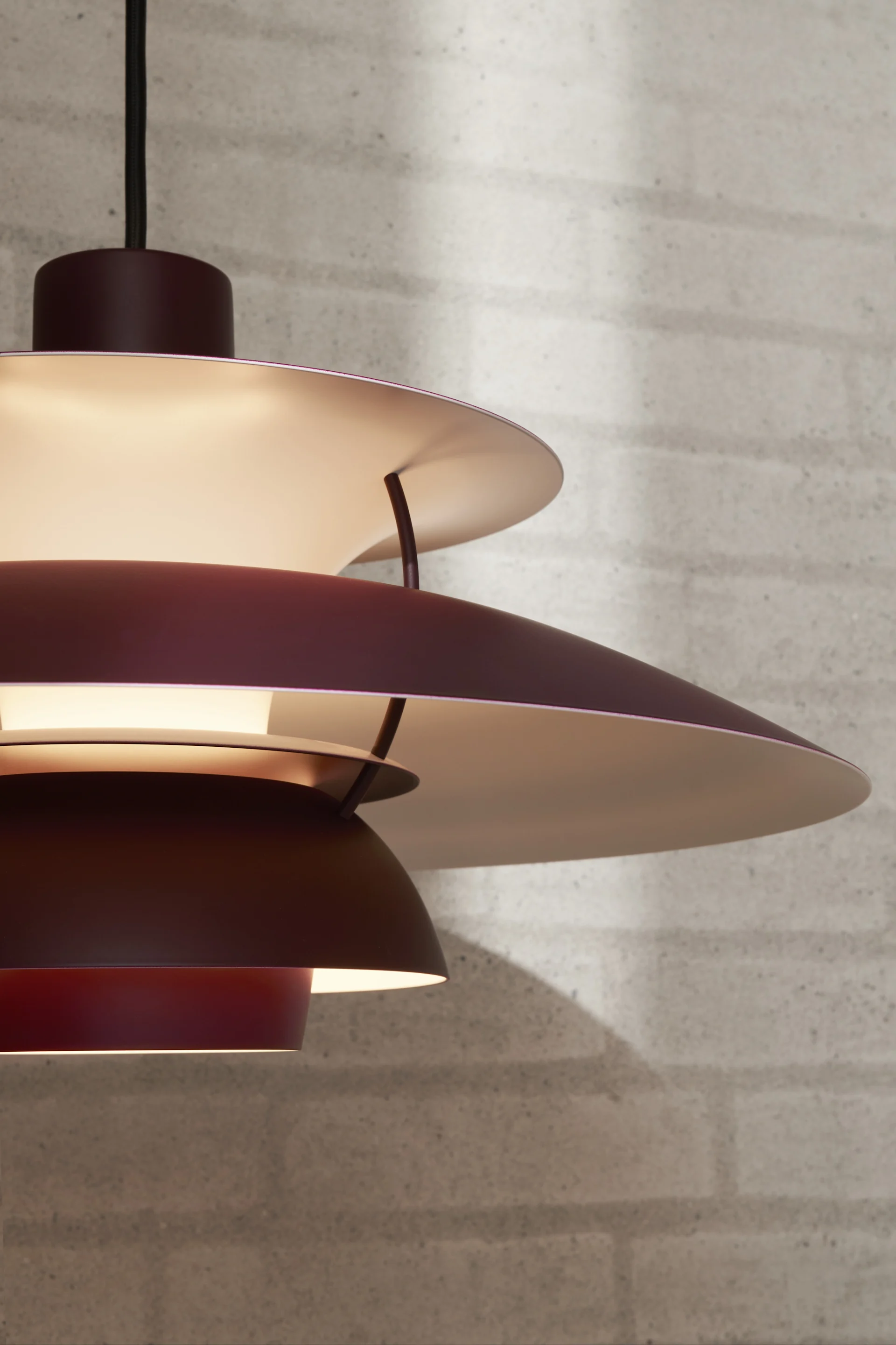 En burgundy PH 5 pendel taklampa som visar på en klassisk designlampa. 