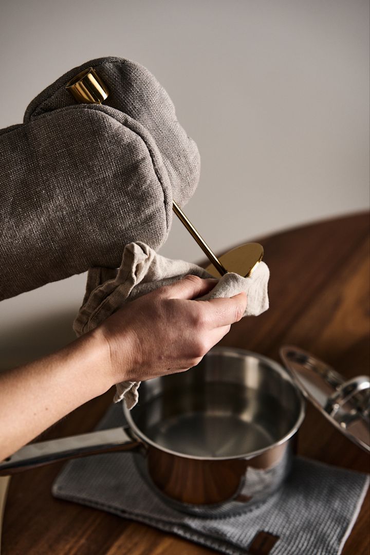 Doppa ner ditt mässingsföremål i hett vatten som husmorstips för att rengöra mässing och putsa mässing med en mjuk handduk för att få den skinande ren.