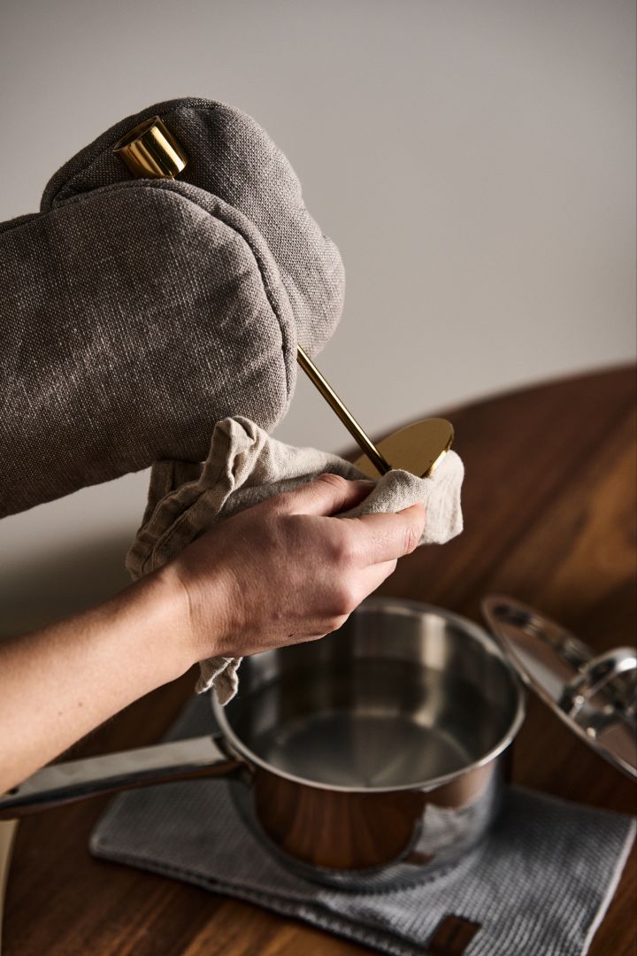 Doppa ner ditt mässingsföremål i hett vatten som husmorstips för att rengöra mässing och putsa mässing med en mjuk handduk för att få den skinande ren.