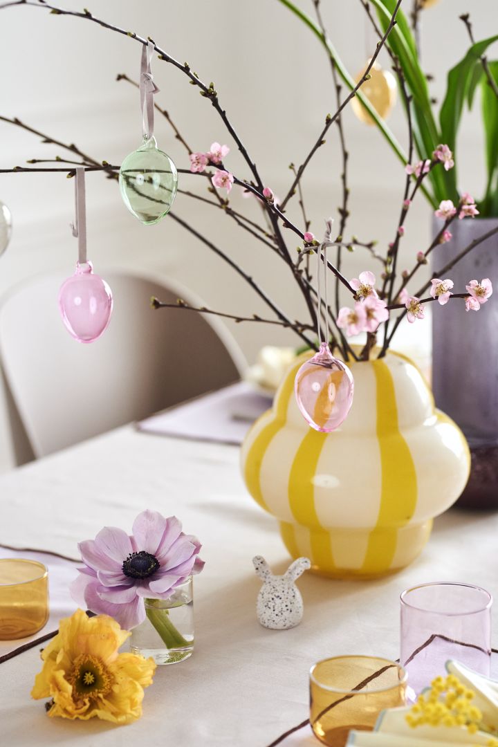 Skapa en festlig påskdukning i vårens pasteller med Iittalas färgglada glasägg i ett vackert påskris som står i Curlie vas från By On.