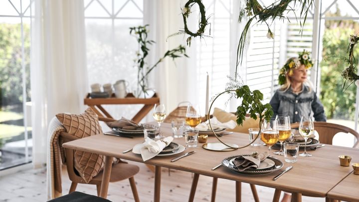 Duka till midsommar i skandinavisk stil som fångar det vackra juniljuset med ljust träbord och trästolar, böljande textilier och jordnära färger.