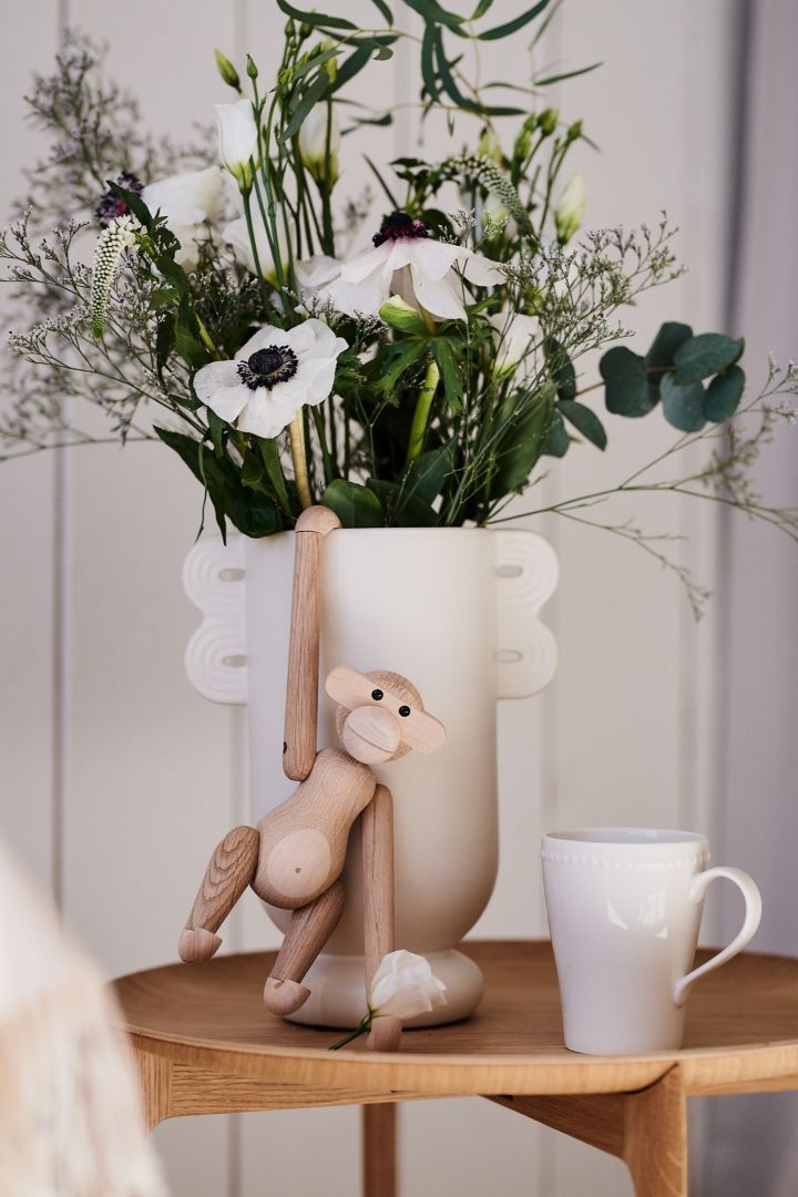 Kay Bojesen apa i ek är en skandinavisk designklassiker och hänger här på en vas med en blomma i handen. 