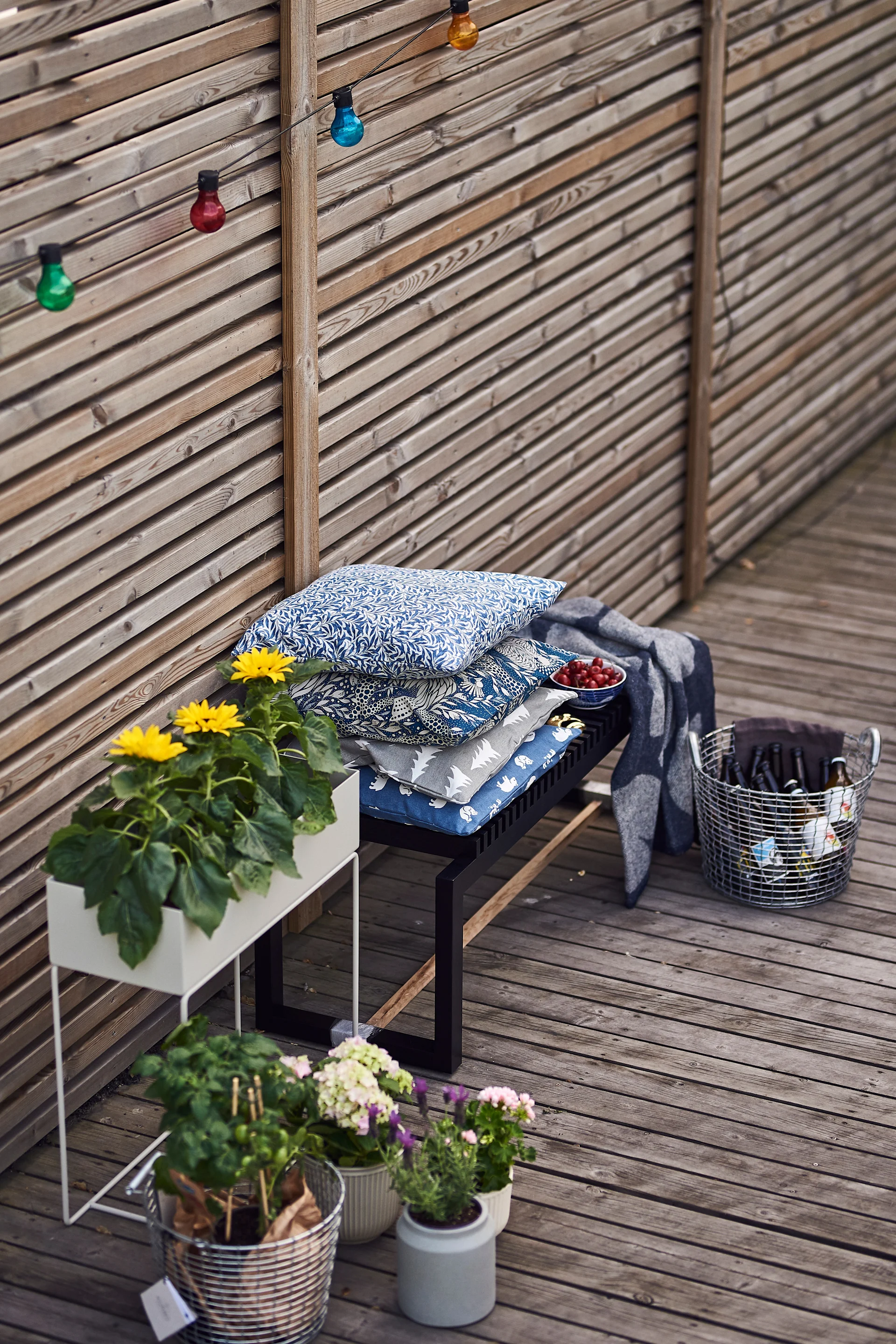 Sommarfestens mingelhörna blir mysig med trädgårdsblommor, kuddar och plädar.
