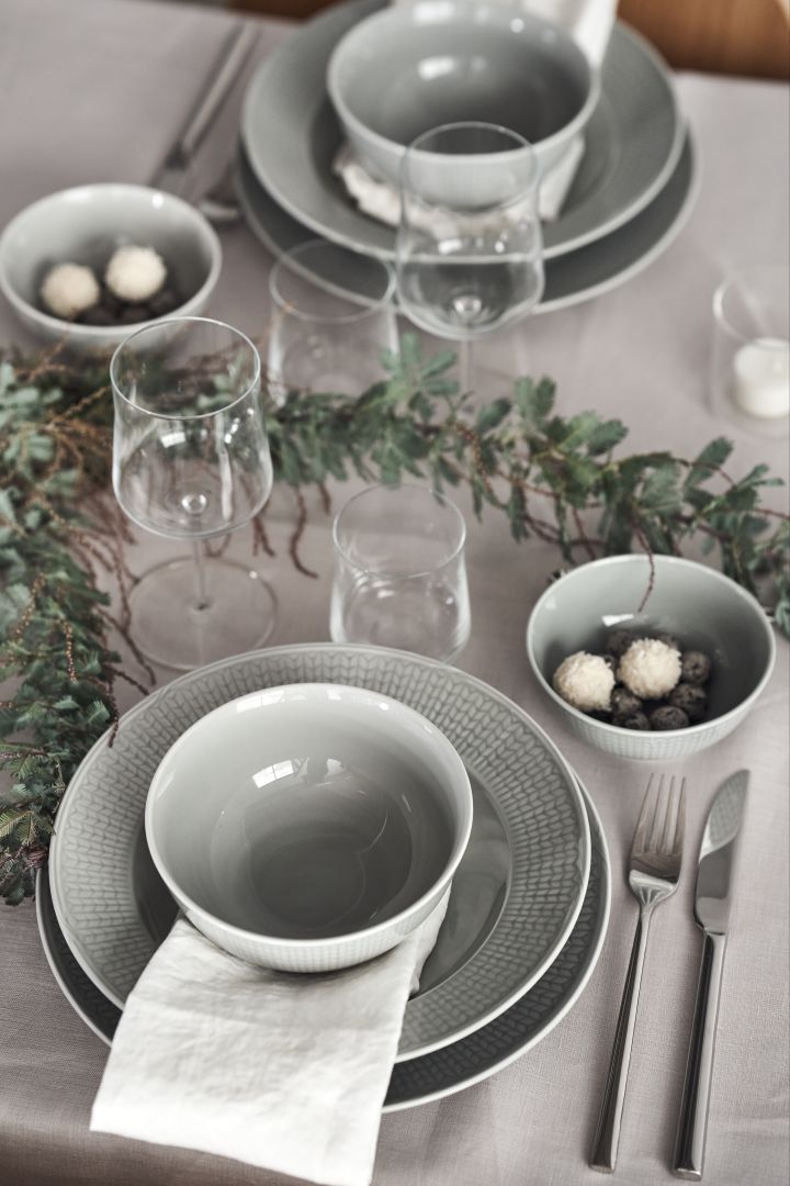 En elegant grå festdukning med Swedish Grace porslin i färgen Dimma, eleganta bestick från Scandi Living och grön växt som löpare på bordet. 