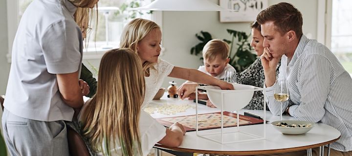 Familjen är samlad vid bordet för en mysig omgång sällskapsspel i sann hygge-anda.