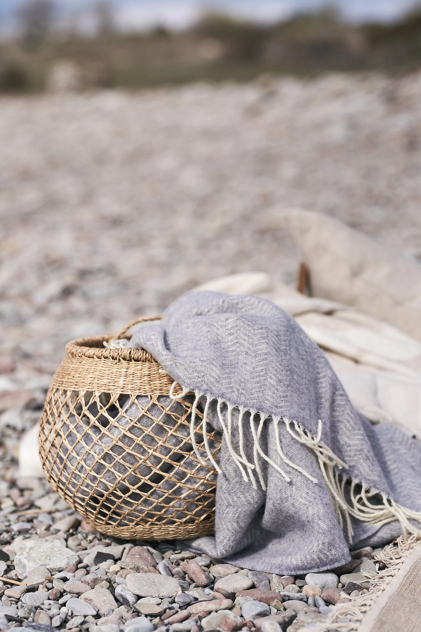 Förvaringskorg i sjögräs med blå ullpläd i.