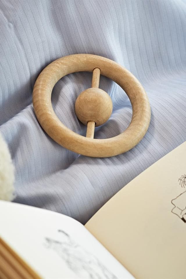 Skallror stimulerar barnets sinnen på olika sätt. Kay Bojesens skallra är ringformad och tillverkad i trä, vilket gör den till en utmärkt present till babyshower.