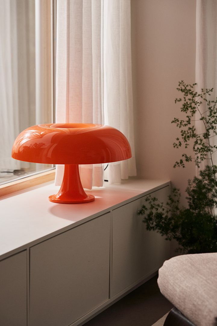 Satsa på färg och inspireras av årets inredningstrender 2024, här Nesso från Artemide på fönsterbrädan i trendig orange färg. 