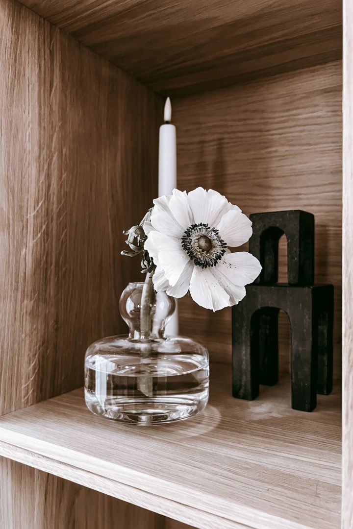 Inreda bokhyllan snyggt - inspiration hemma hos Anela Tahirovic @arkihem där en snittblomma i en fin Marimekko vas skapar ett mer levande intryck i din bokhylla.