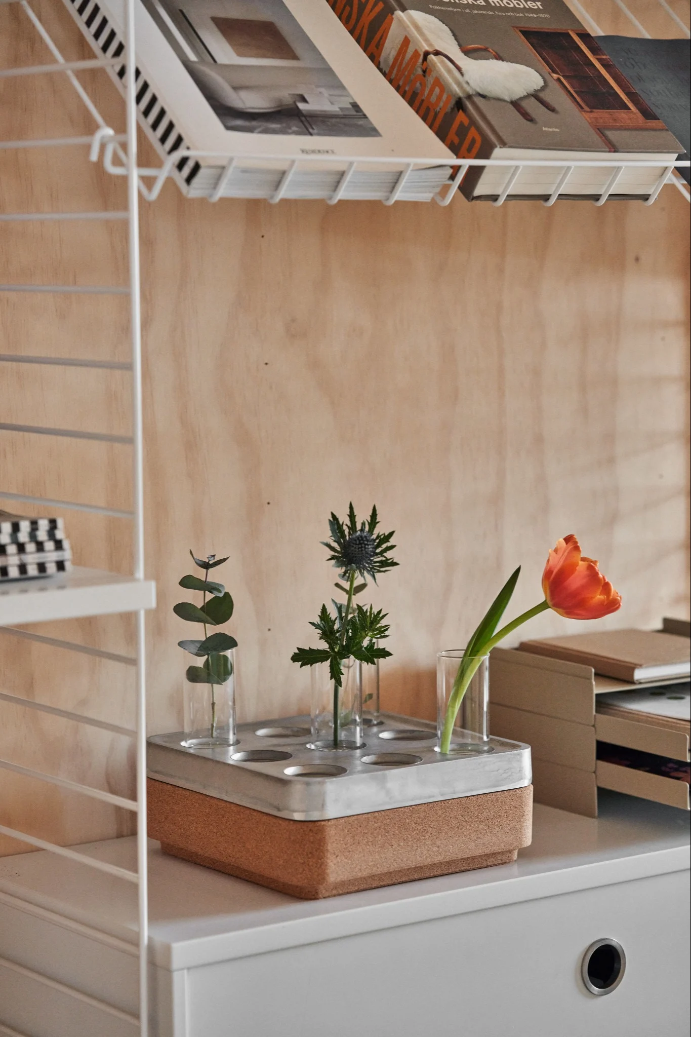 Stumpastaken ljusstake med vas passar i en kontorsmiljö med färska blommor. 