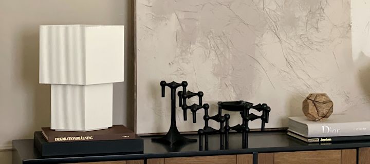 Stilleben med inredning i form av vit Japandi-inspirerad lampa från Pholc och STOFF i svart. 