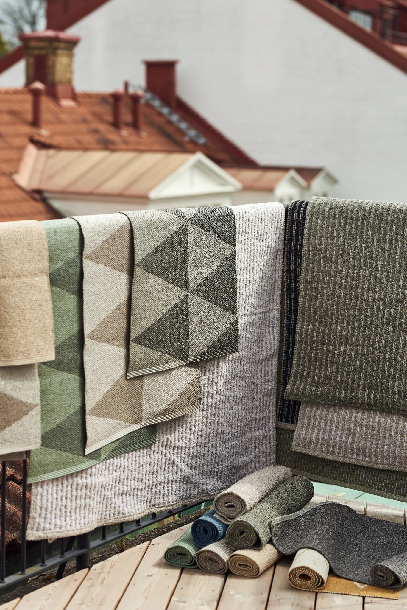 Utomhusmatta: Utomhusmattor från Scandi Living i olika storlekar, material och färger hänga över ett balkongräcke.