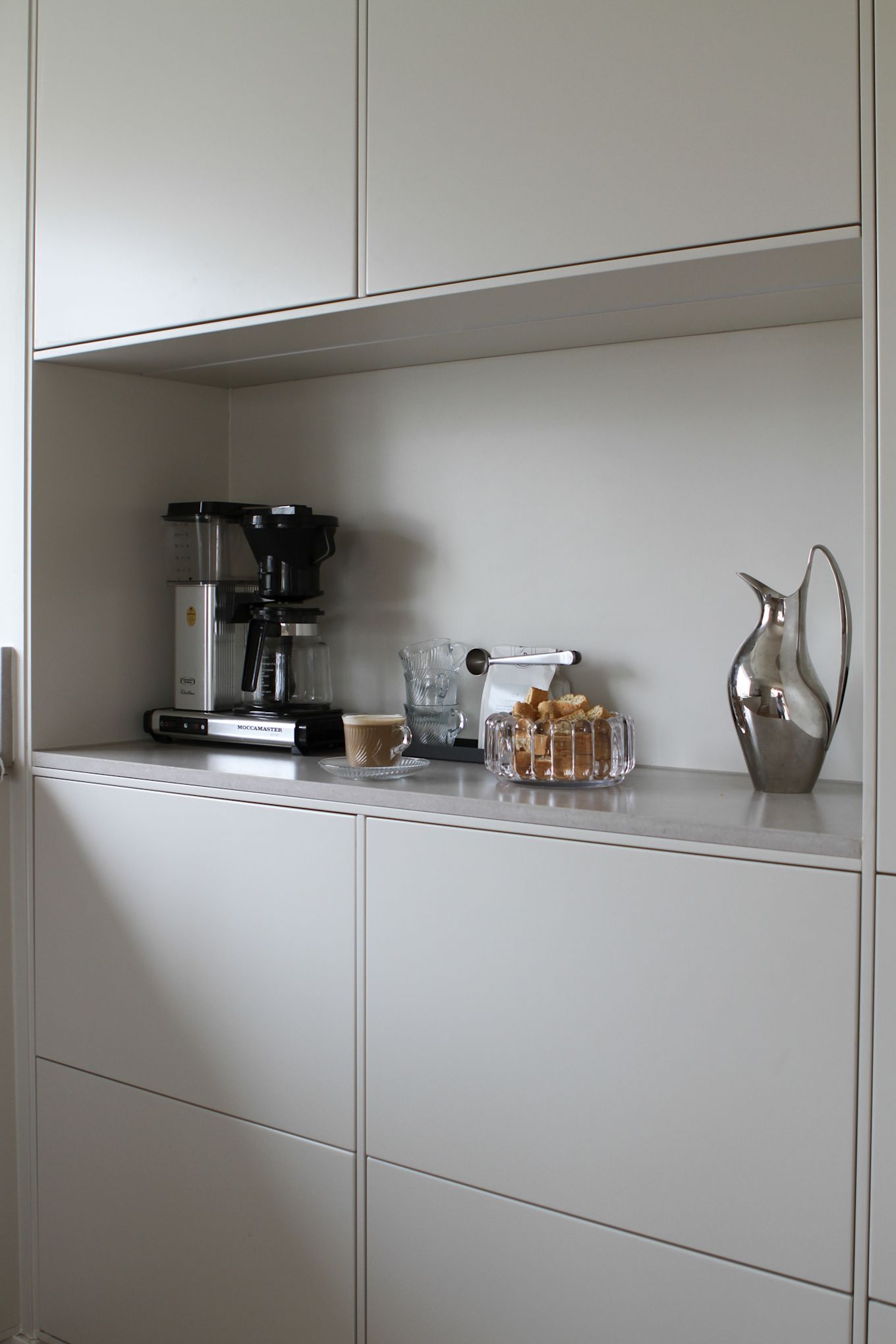 Köksbänken som är nyrenoverad av Moe of Sweden är inredd med kaffebryggare och Georg Jensen HK kanna i silver.