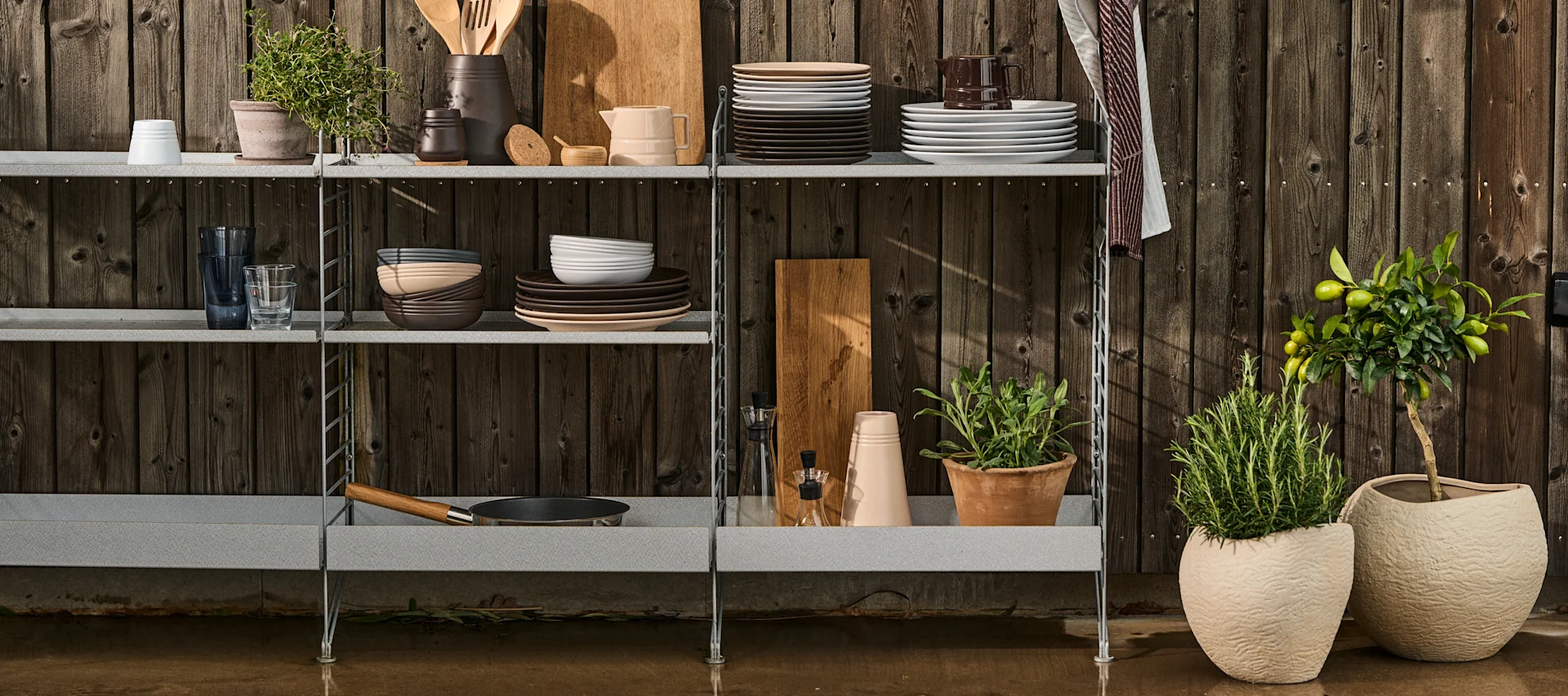 String outdoor, en serie hyllor som är gjorda för att fungera även på uteplatsen, som här i form av ett utekök med plats för porslin, redskap och örter i krukor.