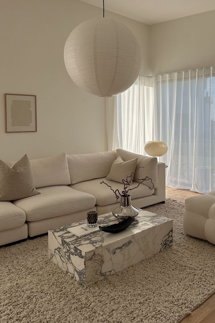 Influencern Helena Jonsson @helenas.hem har inrett med minimalistisk inredning i vardagsrummet med beigt ton-i-ton, ett soffbord i marmor och detaljer i krom.