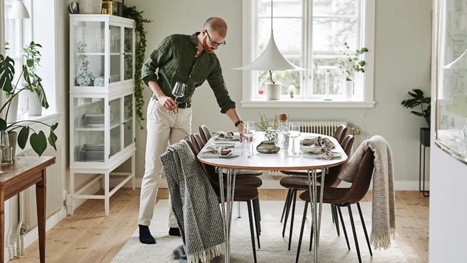 En ljus matplats med skandinavisk inredning och stil i fokus med mycket textilier, gröna växter och designikoner som Semi taklampa från Gubi.