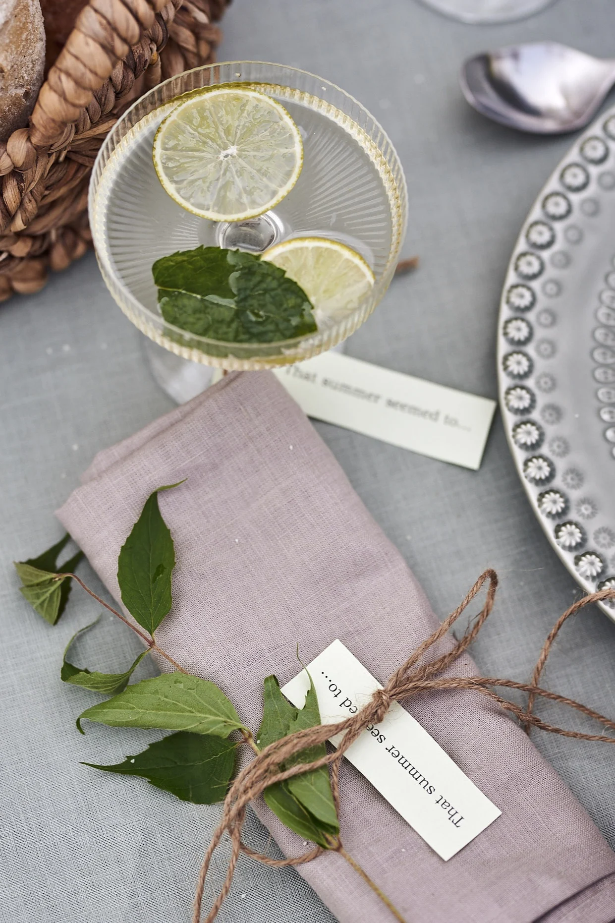 Tips till trädgårdsfesten är sommarlåtar skrivna på lappar och knutna runt välkomstdrinken som bordsplaceringskort.