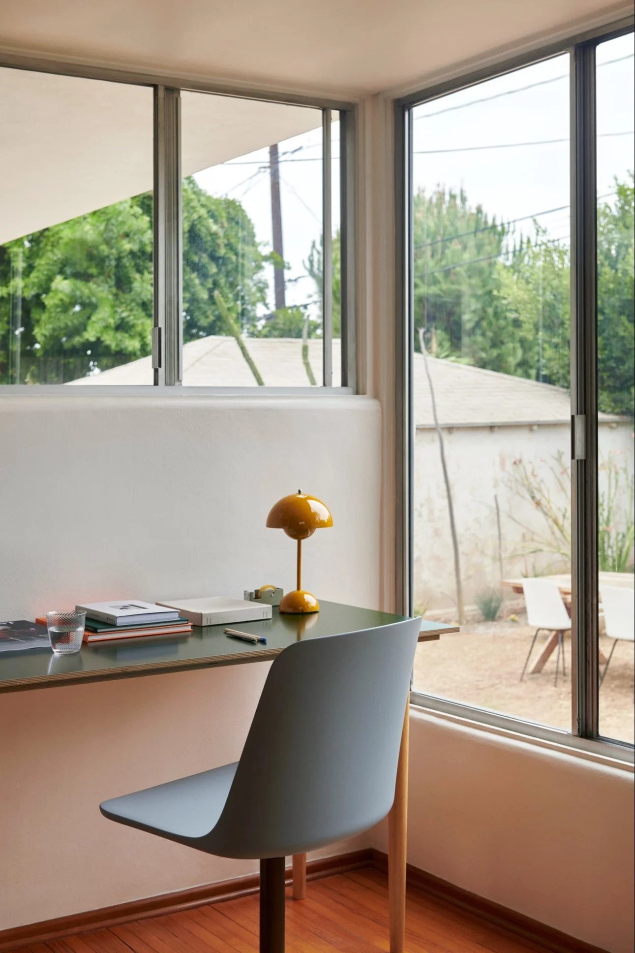 En Flowerpot bordslampa i gult står på ett skrivbord och är en klassisk designlamap.