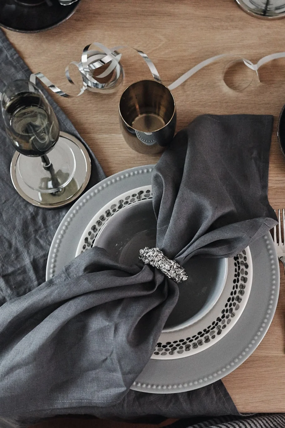 Duka till nyår i kalla toner av grått för en dukning i silver. Här ser du Byon servettring tillsammans med Dots porslin från Scandi Living.