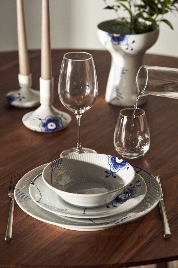 Ett dukat bord med Blue fluted mega tallrikar, ljusstakar och vas från Royal Copenhagen i klassiskt blåvitt.