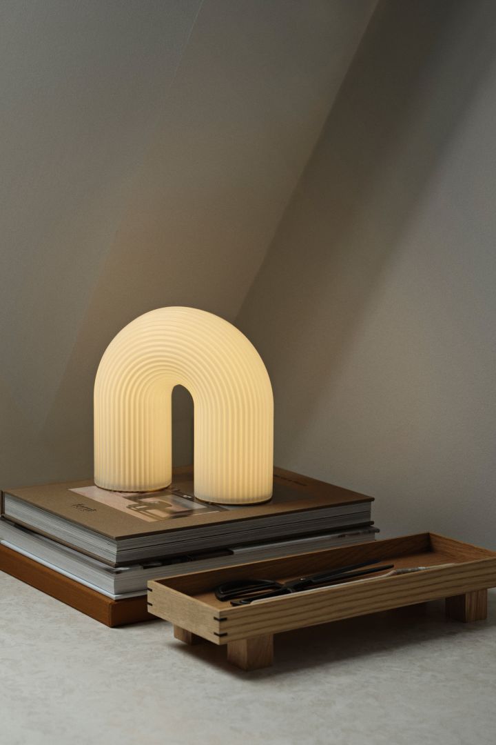 Vuelta bordslampa från Ferm Living är en bågformad liten bordslampa med räfflat glas. En perfekt sovrumslampa som ger fint och mjukt ljus.
