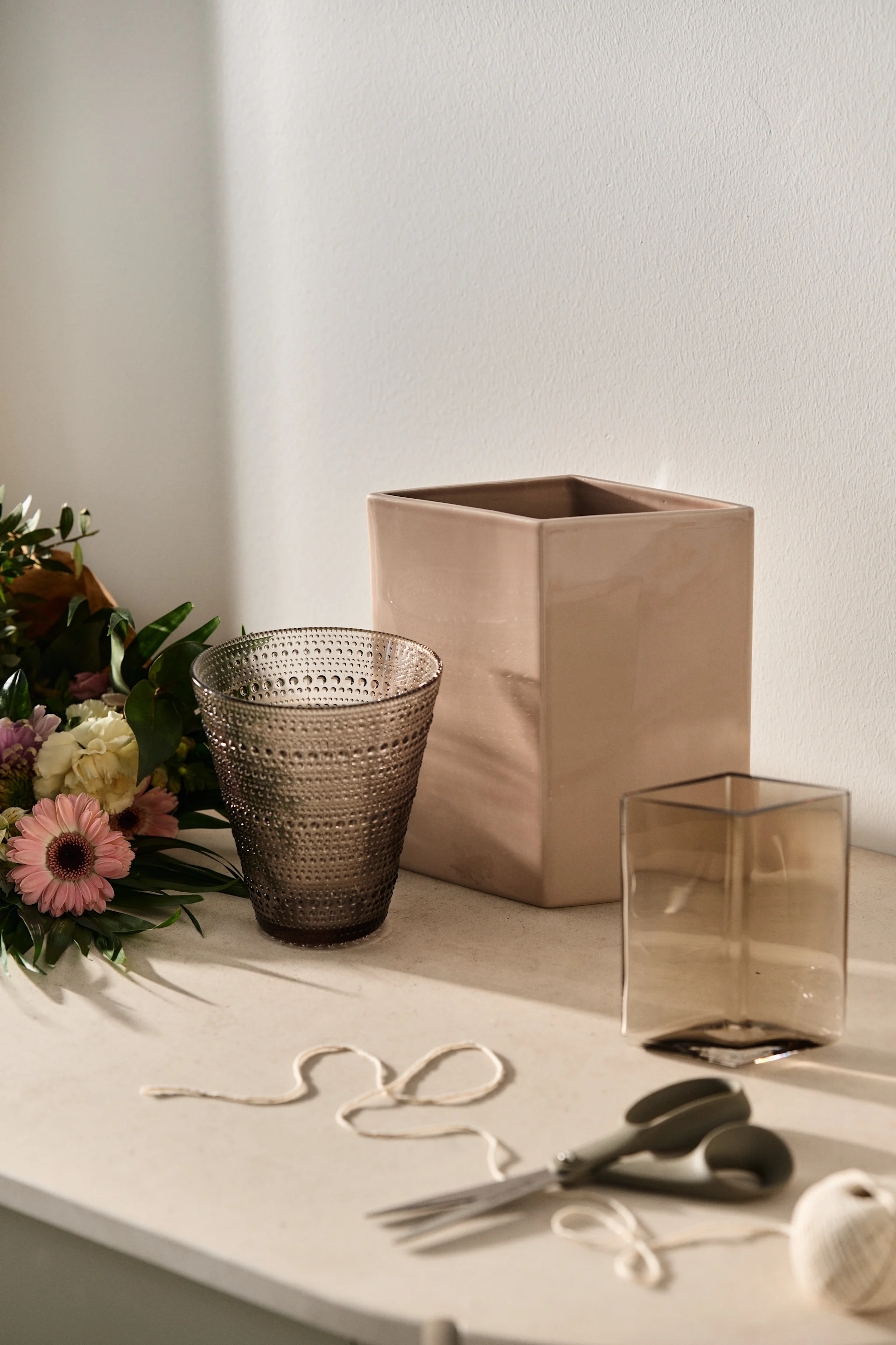 En blomsterbukett och vas som presentkit är perfekt som morsdag present. Här ser du Kastehelmi och Ruutu vaser från Iittala i jordnära färger.