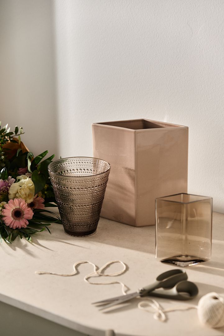 En blomsterbukett och vas som presentkit är perfekt som morsdag present. Här ser du Kastehelmi och Ruutu vaser från Iittala i jordnära färger.