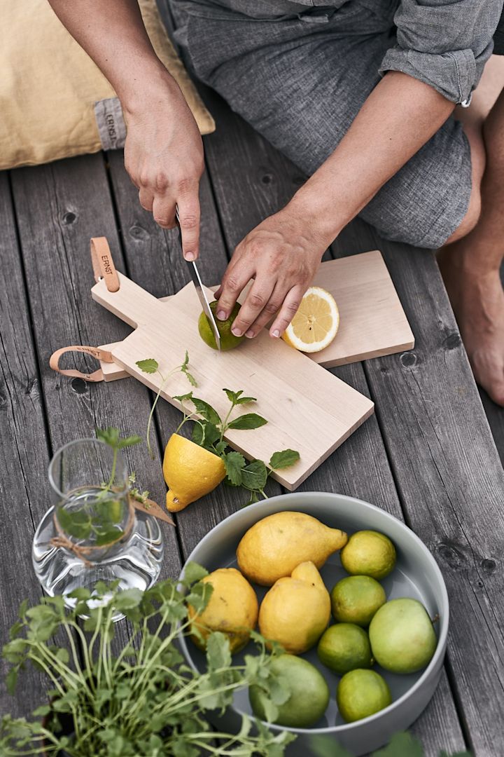 Det skivas citron och lime på terrassen för att göra svalkande lemonad till sommarlunchen. 
