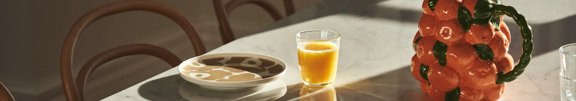 Dukat bord med Marimekko-porslin, juice och karaff från BYON i utförandet av mandariner. 