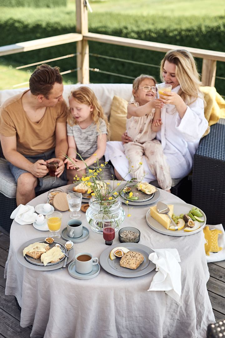 Uppdukat för hotellfrukost hemma på terrassen med kaffe, frukt och mackor för en mysig och lyxig frukost. 