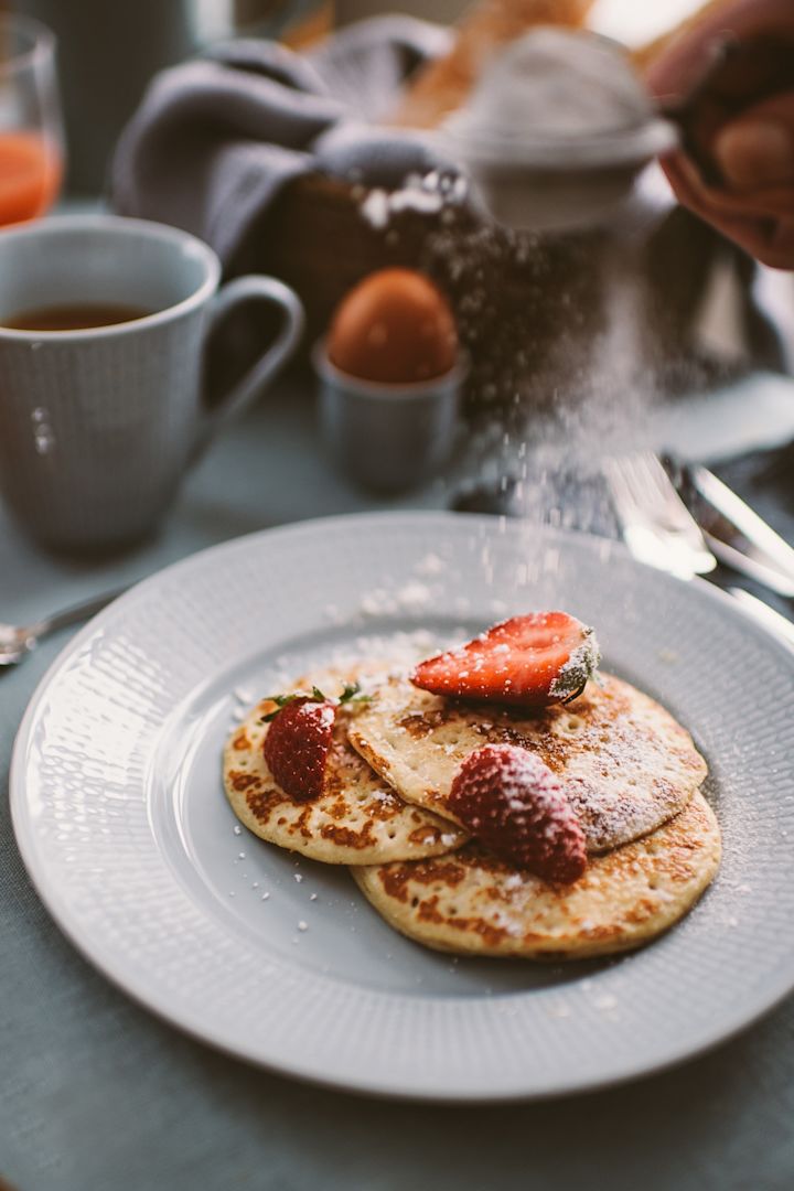 Pannkakor pudrade med florsocker och serverade med färska jordgubbar, här på Swedish Grace assiett blir ett gott avslut på din helgfrukost.