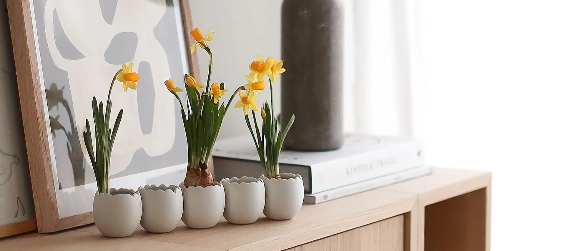 Två ball vaser i olika former och storlekar från Cooee Design med vårblommor står på en bricka, bredvid flera trillingar av påskharar från DBKD i @sachi_rooooms hem.