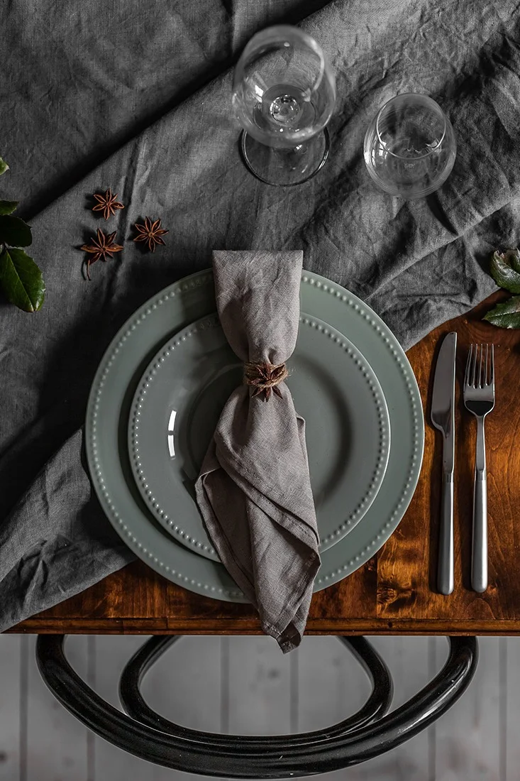 Tallrikskuvert till jul med grönt porslin från Scandi Living och knuten linneservett.