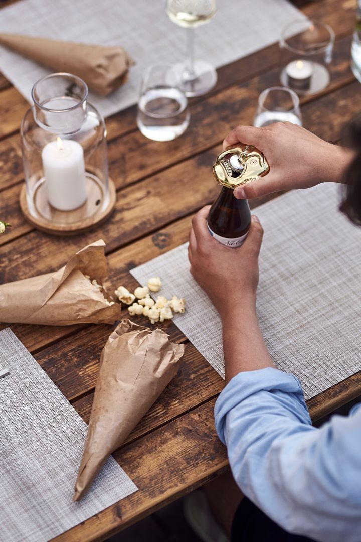 Open sesame flasköppnare från Skultuna används att öppna ölen med medan popcornstrutar ligger på bordet som festlig detalj.