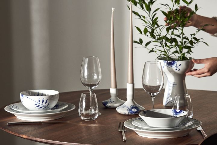 Ett dukat bord med Blue fluted mega tallrikar, skålar, ljusstakar och vas från Royal Copenhagen i klassiskt blåvitt.