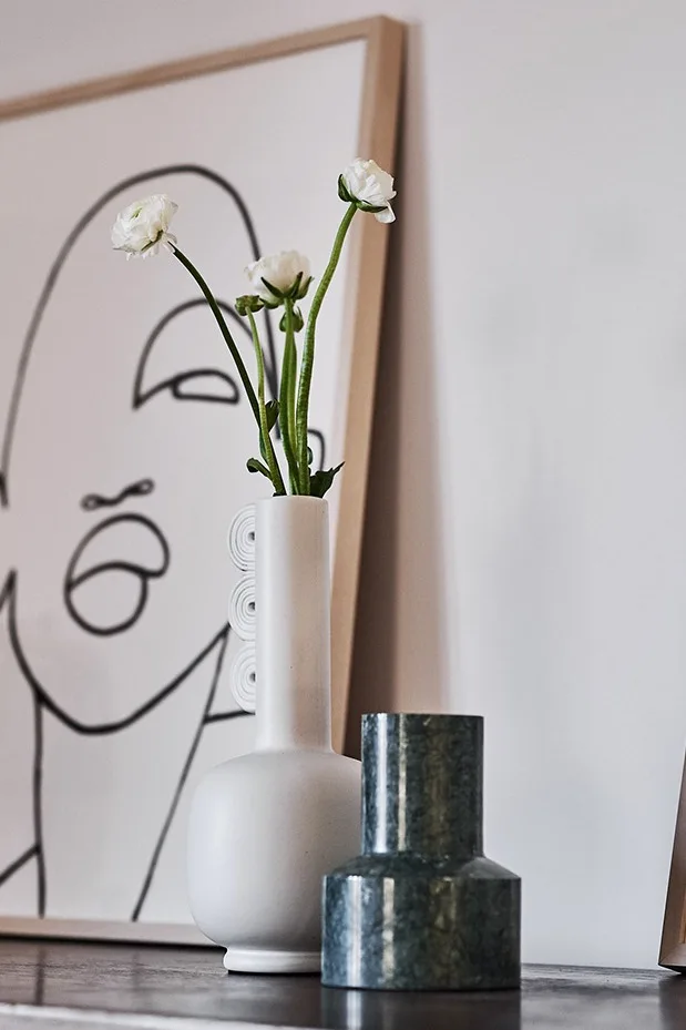 Chunk ljusstake i grön marmor från House Doctor & vit Muses vas från Ferm Living sprider stämning på byrån i matplatsen.