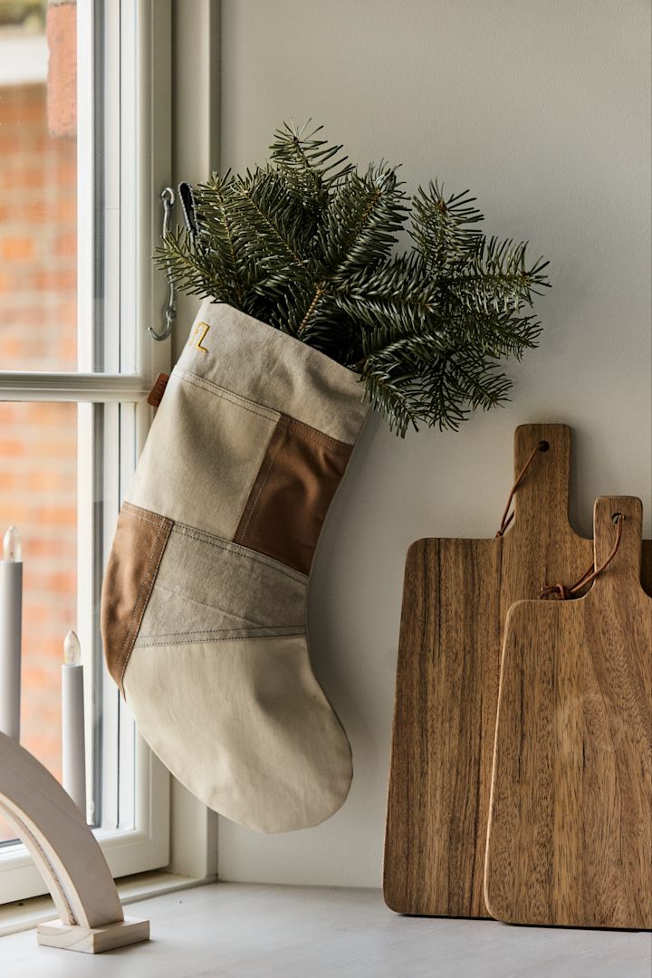 Pynta din julstrumpa med granris dekoration för att skapa julstämning i hemmet. Här ser du Tonal julstrumpa från ferm LIVING i beigea och vita toner.