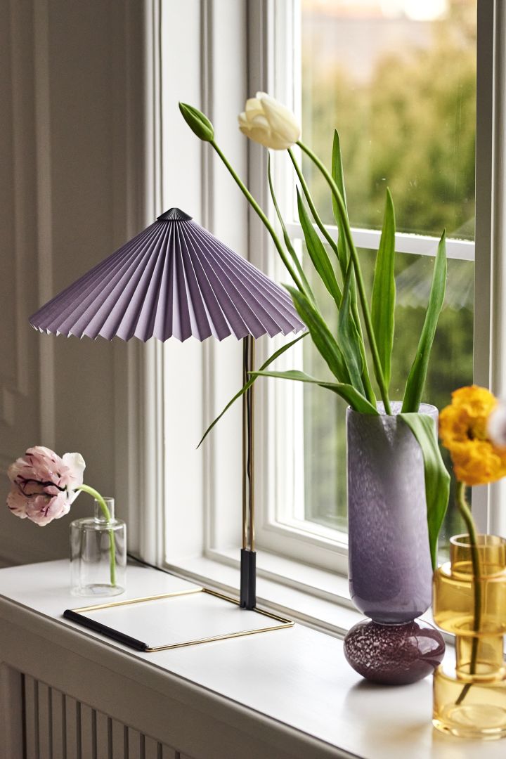 Vårens inredningstrender 2023 bjuder på retro-stilen plisserade lampor där vi gärna inreder med trendiga Matin bordslampa från HAY med lila plisserad lampskärm.