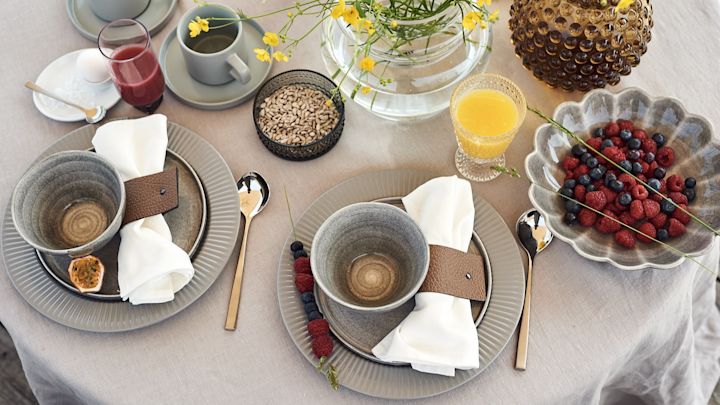 En lyxig och mysig frukostdukning för hotellfrukost hemma med skålar från Mateus och tallrikar från Eva Solo med juice och bär på bordet. 